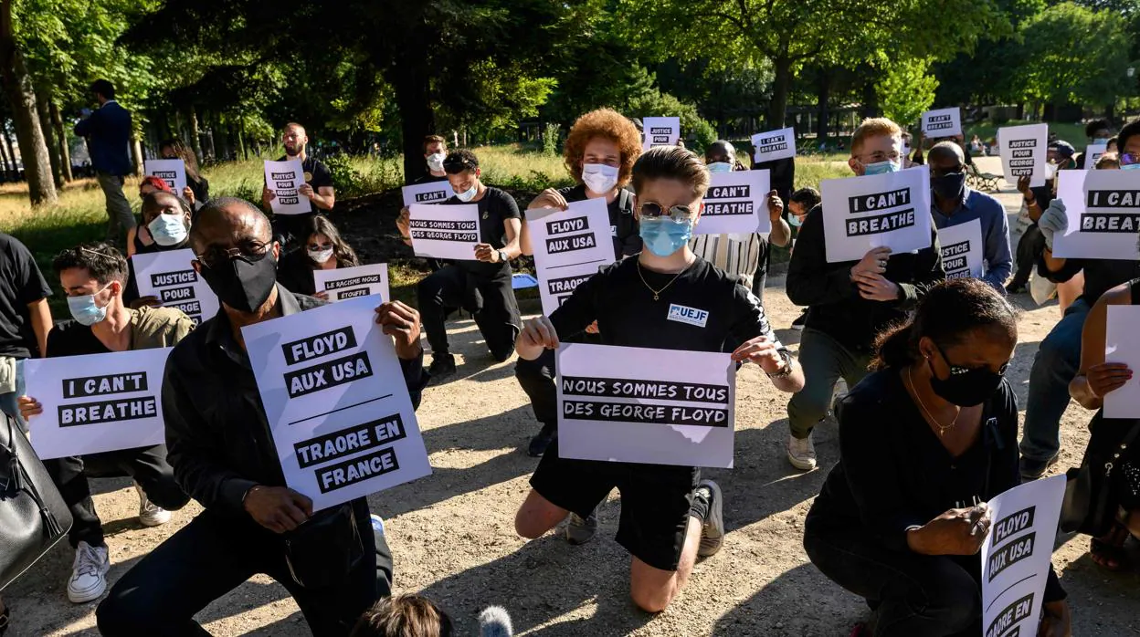 Un grupo de jóvenes sostienen pancartas con mensajes de solidaridad a la muerte del afroamericano George Floyd, en París