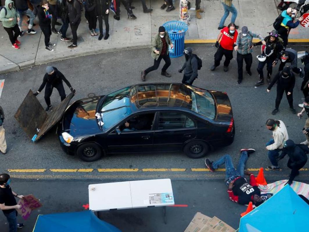 Un hombre cae después de ser disparado por un conductor en una protesta en Seattle por la muerte de George Floyd