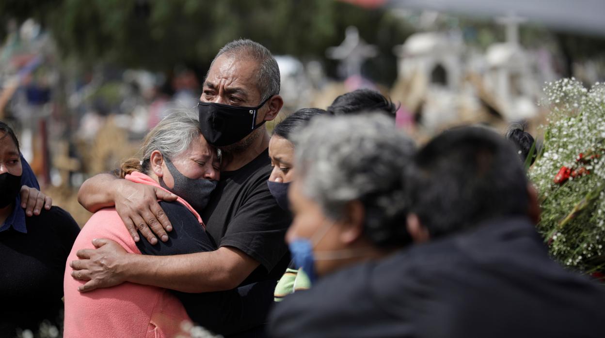 Familiares de una víctima de Coronavirus se consuelan en el cementario de Xico, en el Valle de Chalco (Mexico)