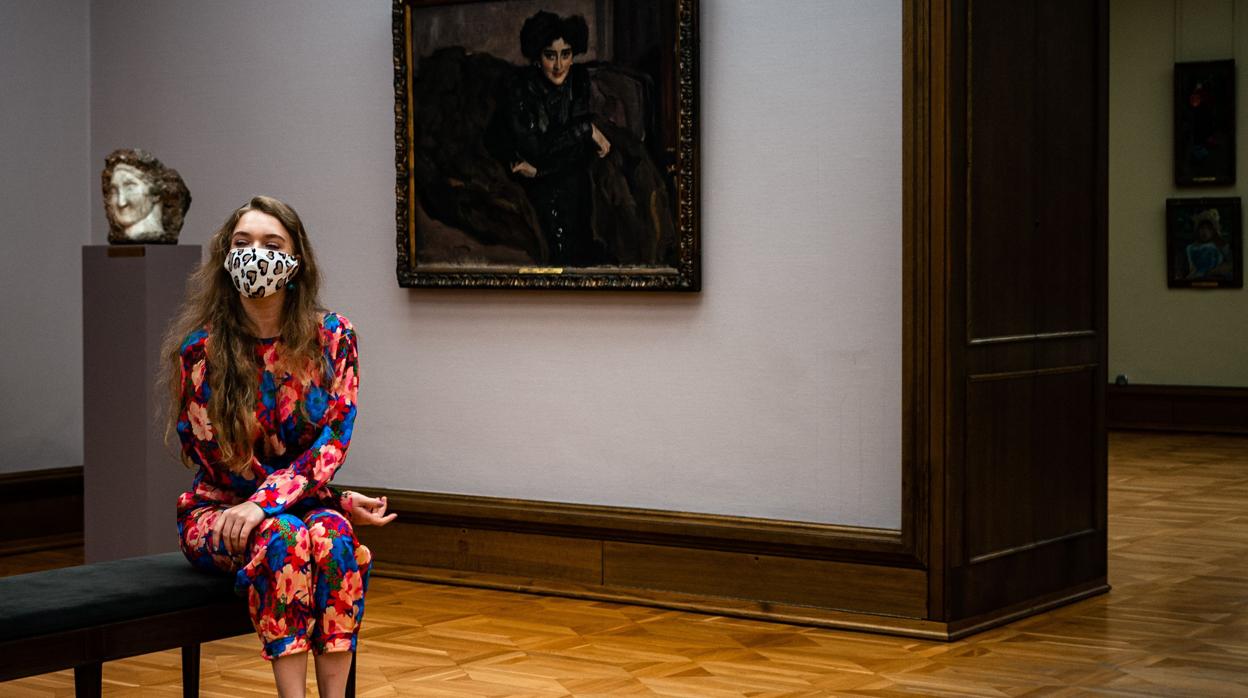 Una mujer protegida con una mascarilla visita la galería Treatiakov de Moscú