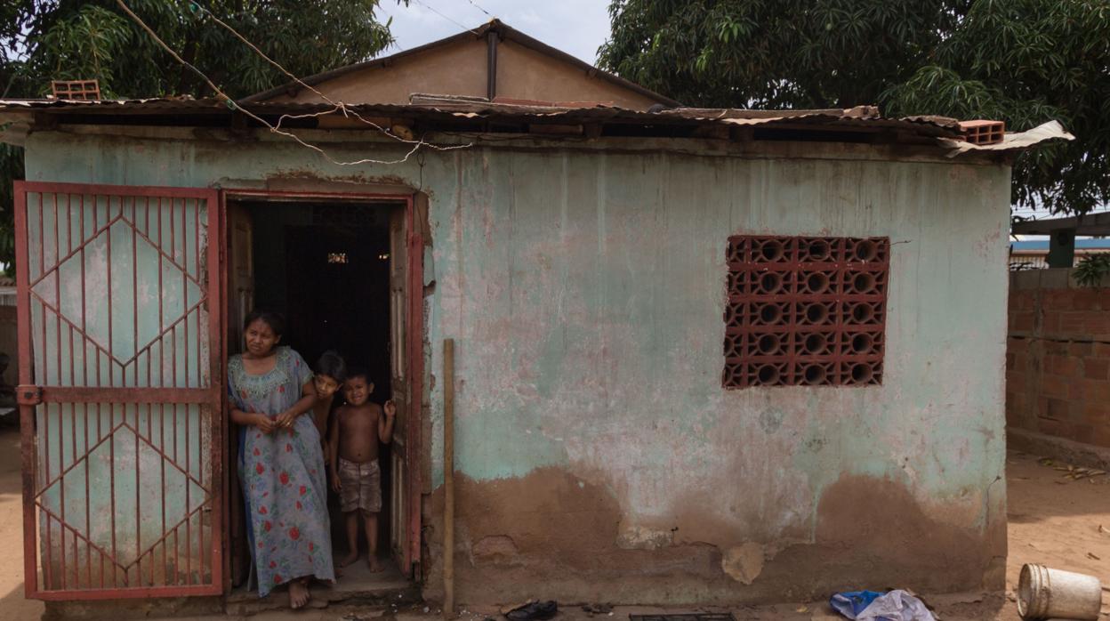 María González se para el 25 de junio a la entrada de su casa donde cocinan con madera, en Maracaibo