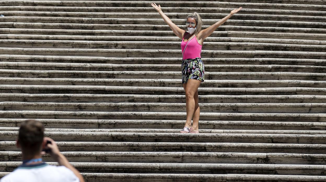 Una turista posa en las escaleras de la Plaza de España en Roma