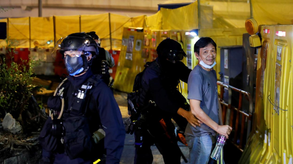 La Policía cachea a un hombre durante una protesta en Hong Kong