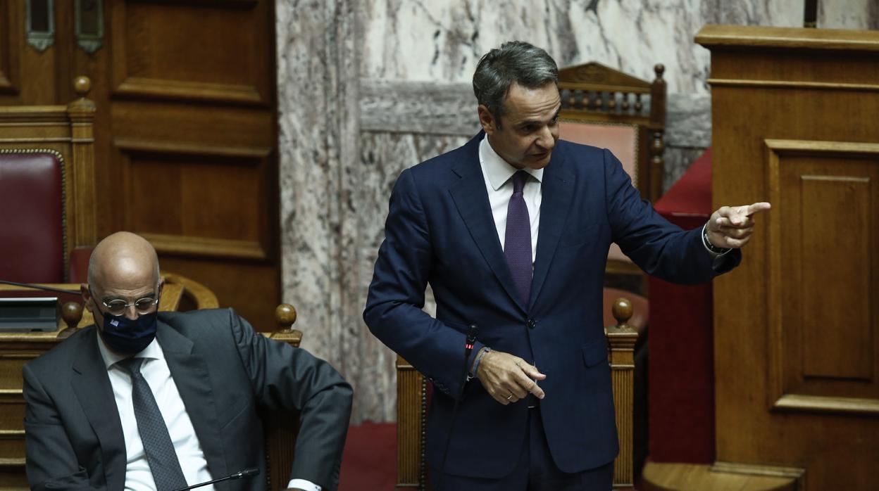 El primer ministro griego, Kyriakos Mitsotakis, da un discurso este miércoles en el Parlamento al lado del misnistro de Exteriores del país, Nikos Dendias