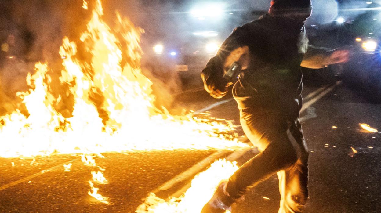 Un manifestante con los pies en llamas al ser alcanzados por un cóctel molotov, en un Portland (Oregón)
