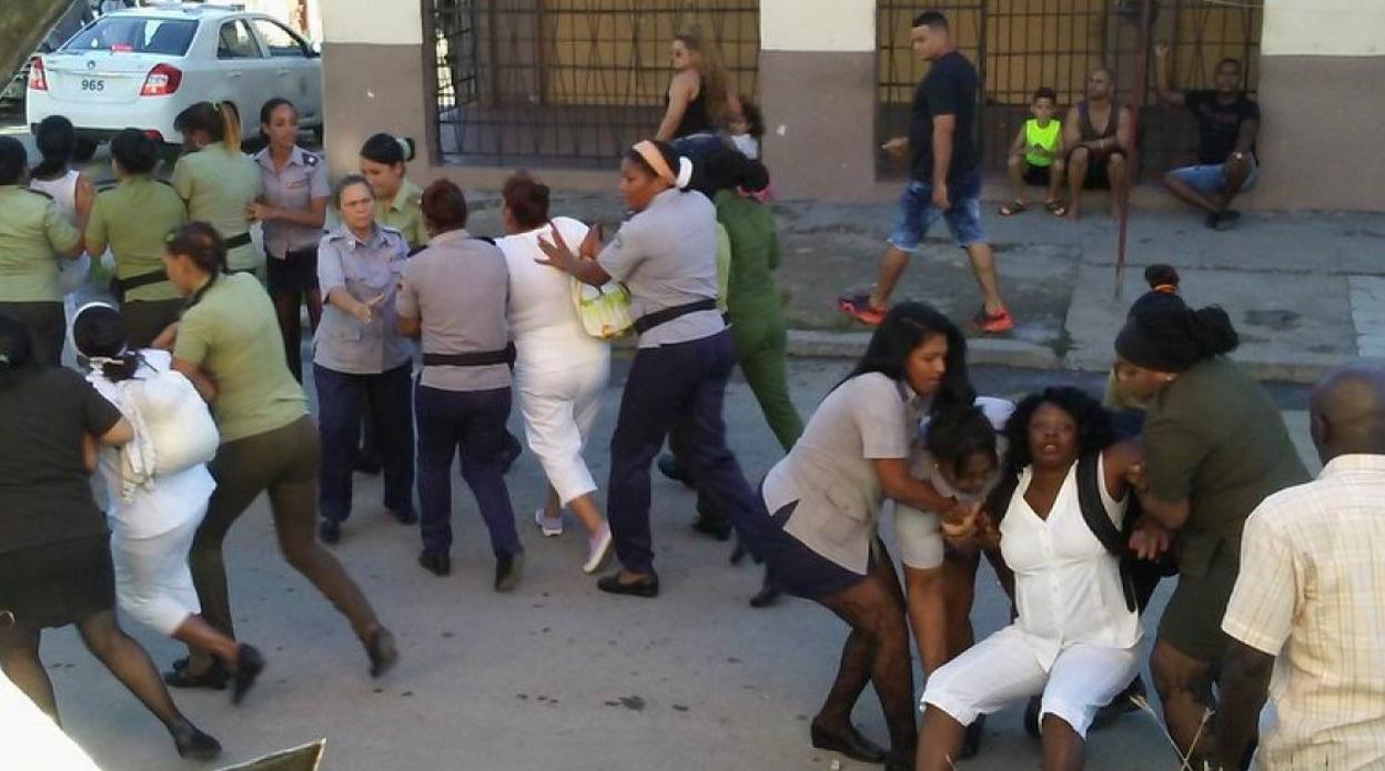 Agentes de la Seguridad del Estado detienen a varias Damas de Blanco. A la derecha, Berta Soler