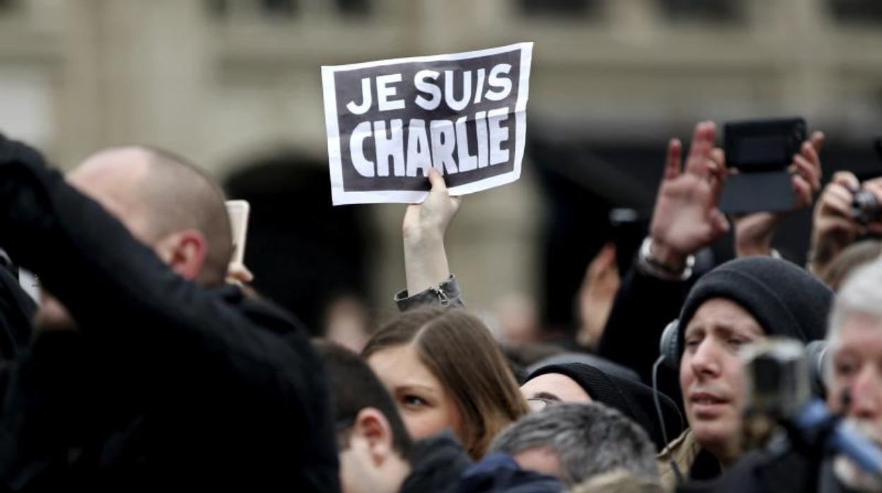 Una persona sostiene un cartel con el texto «Je suis Charlie» durante un homenaje a las víctimas del tiroteo de Charlie Hebdo