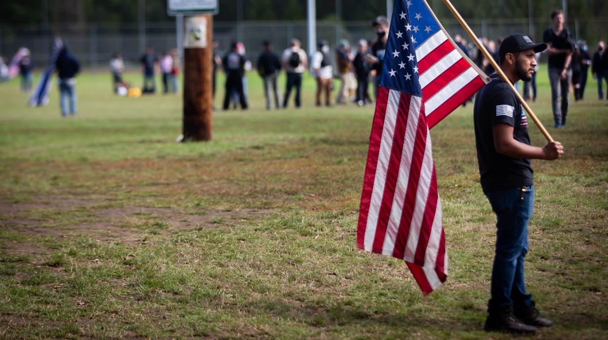 Un hombre sostiene una bandera de los Estados Unidos durante una marcha de los Proud Boys