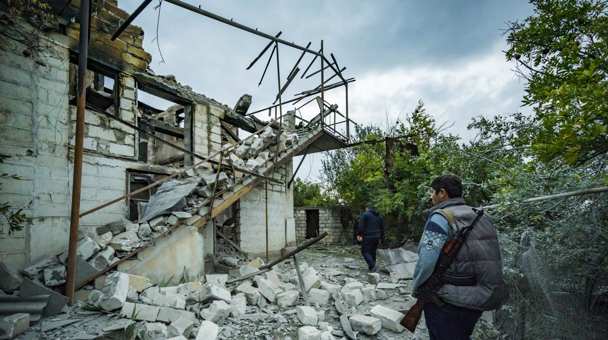 Un hombre inspecciona una casa destruida por los combates entre Armenia y Azerbaiyán