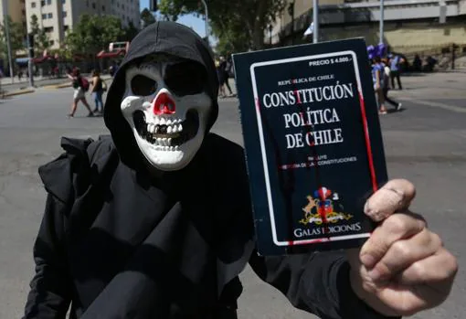 Un hombre sostiene la actual constitución chilena, que será sometida a un referéndum el próximo domiingo