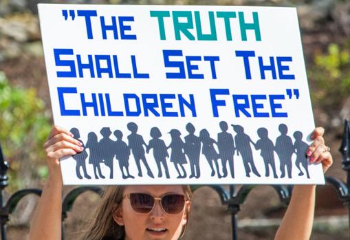 Una mujer en un mitin de QAnon en el que dice: "La verdad hará a los niños libres"