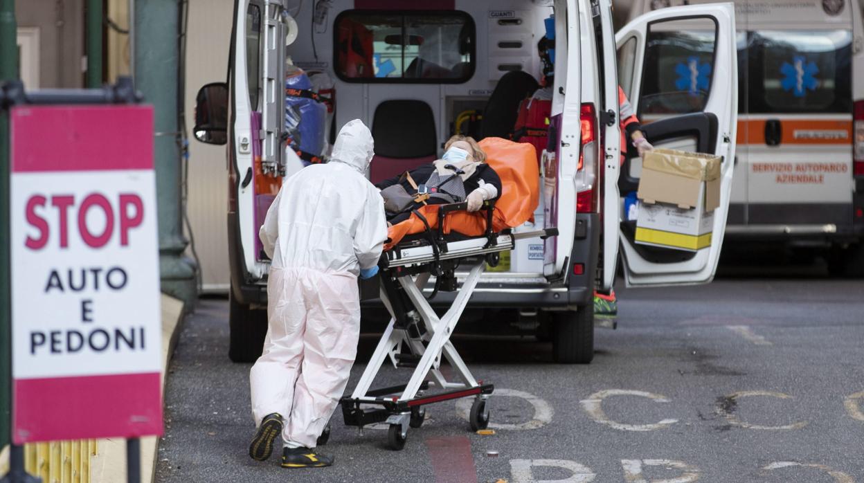 Un miembro del personal sanitario conduce a un hombre a un hospital en Roma