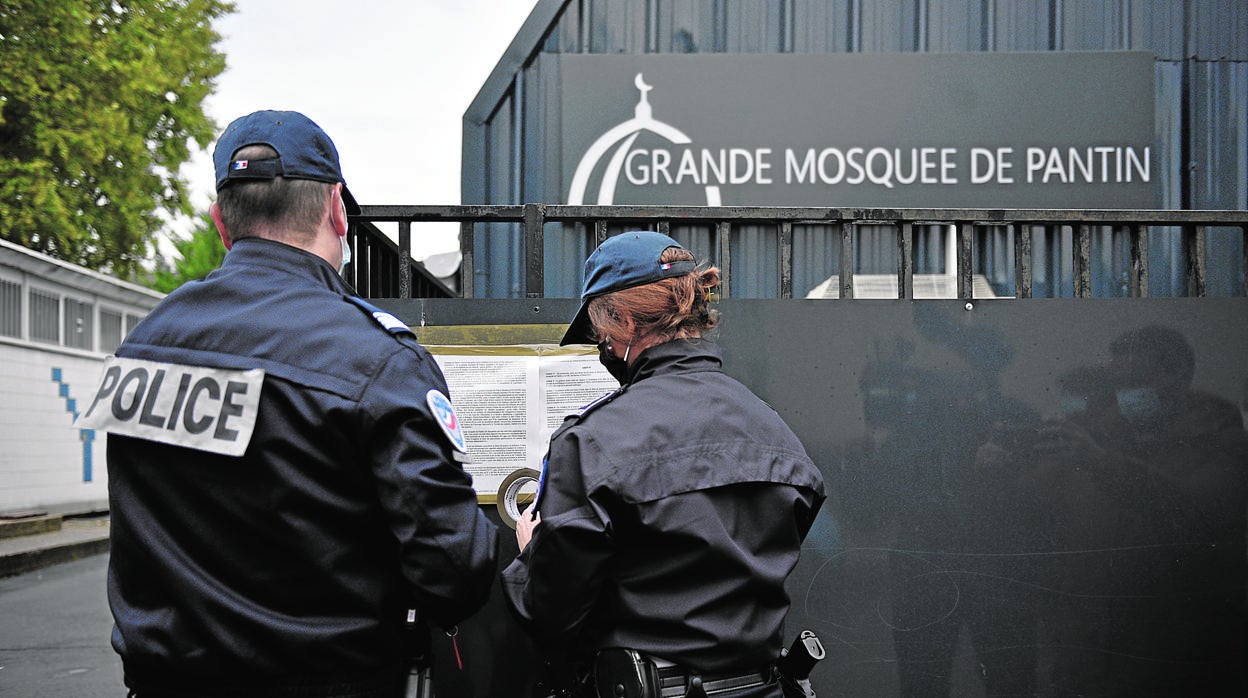 Dos policías franceses colocan en la entrada de una mezquita radical del norte de París un decreto de cierre