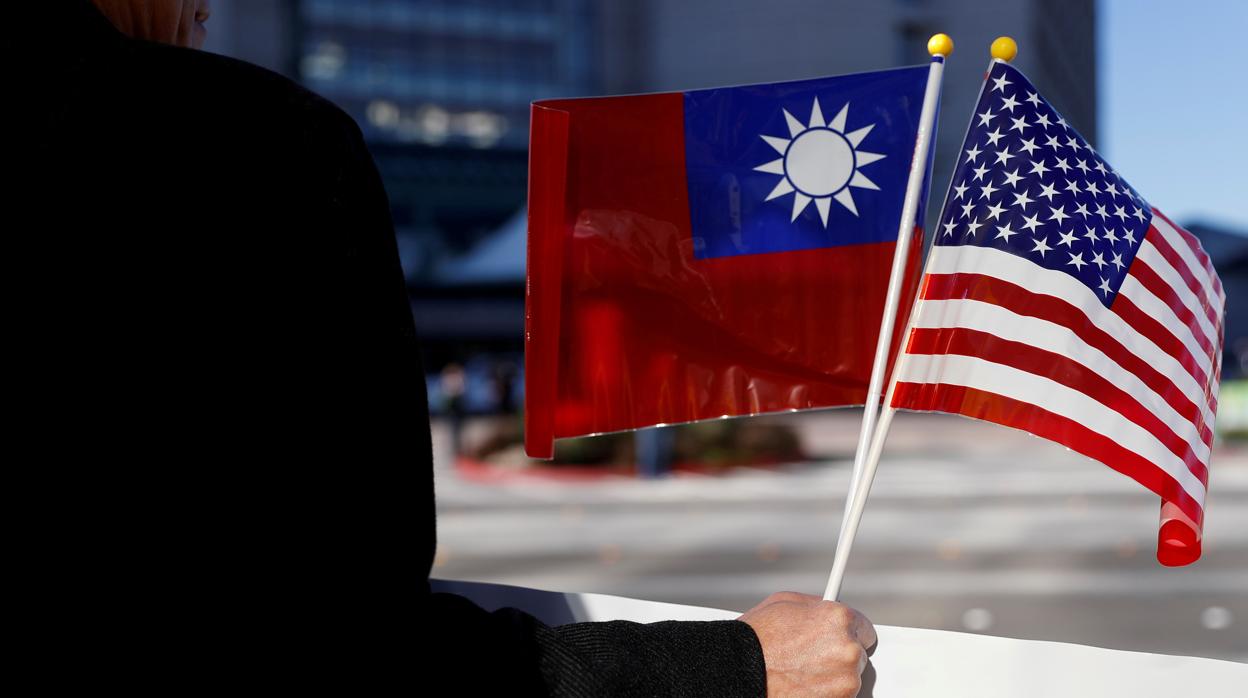 Un hombre sostiene una bandera de Taiwán y otra de Estados Unidos