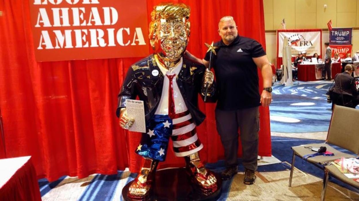 Un participante en la Conferencia conservadora de Orlando se hace fotografiar con la estatua de Trump