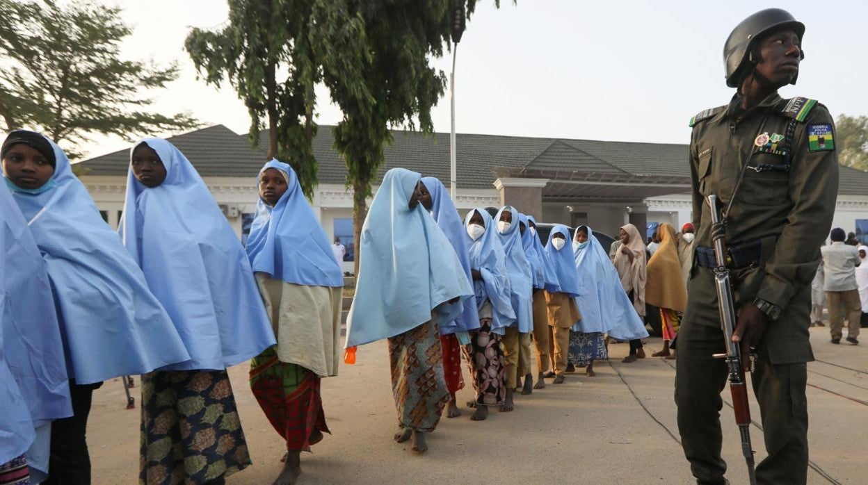 Varias de las niñas liberadas pasan junto a un oficial de policía