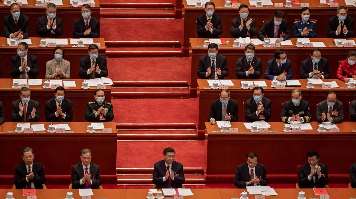 El presidente de China, Xi Jinping, aplaude con otros líderes y delegados después de que votaron sobre los cambios en el sistema electoral de Hong Kong