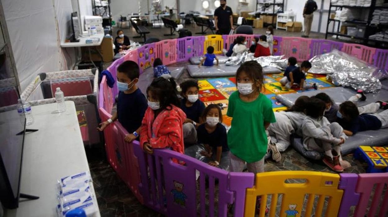 Menores no acompañados, de entre tres y nueve años, ven la televisión en unas instalaciones del Departamento de Seguridad Nacional de EE.UU. en Donna (Texas)
