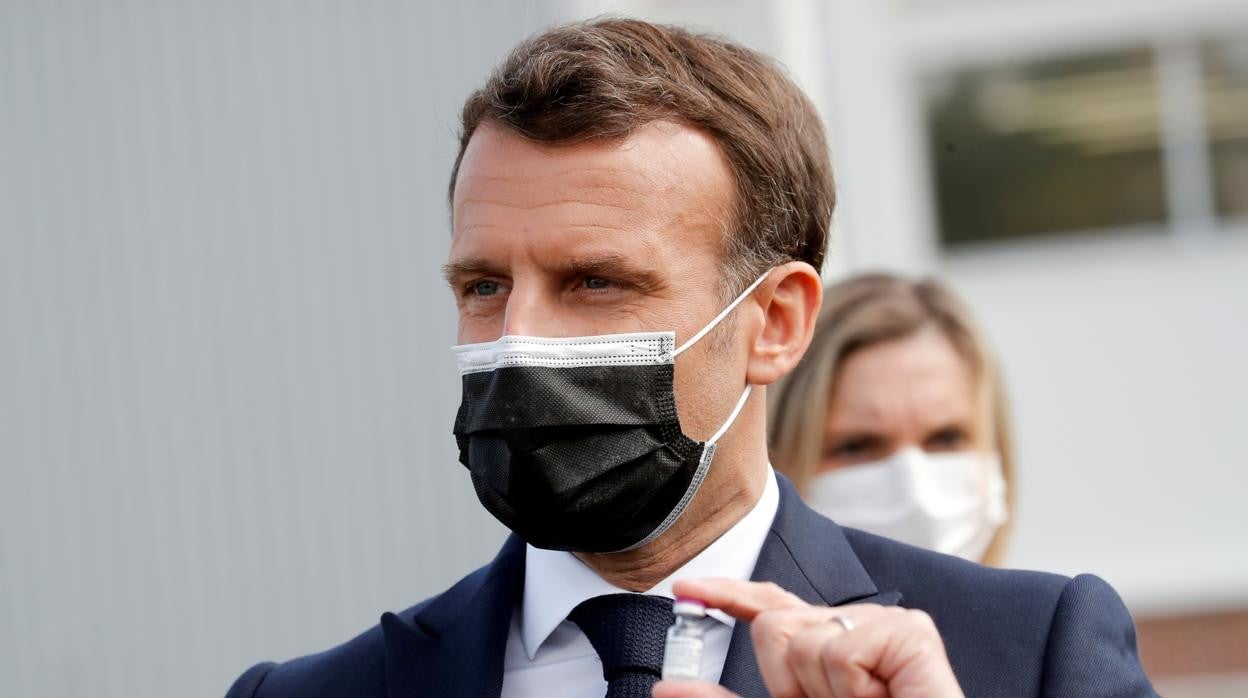 Emmanuel Macron sostiene un frasco de una vacuna después de visitar la planta de Delpharm en Saint-Remy-sur-Avre, al oeste de París