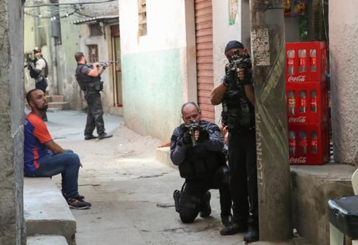 Varios agentes apuntan con sus armas en las calles de la favela de Jacarezinho