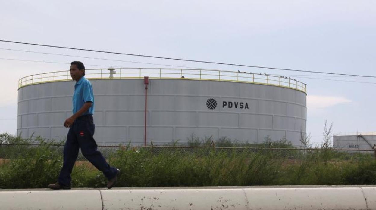 Un hombre pasa frente a un tanque de Pdvsa en Ciudad Ojeda (Venezuela)