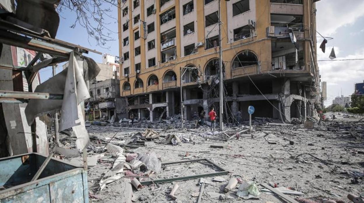 Varios palestinos observan los daños en la torre Al-Jawhara tras un ataque aéreo israelí