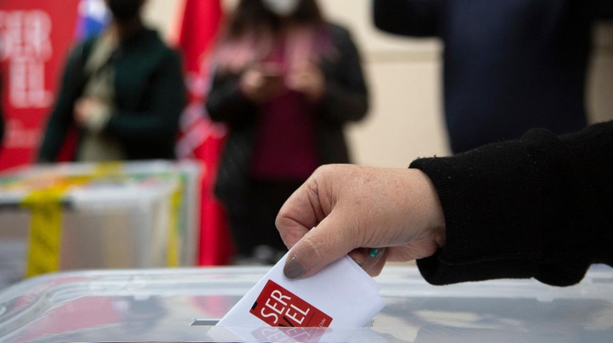 Una persona deposita su voto en la urna electoral, en Santiago