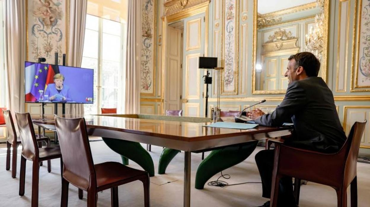 El presidente francés, Emmanuel Macron, habla con la canciller alemana, Angela Merkel