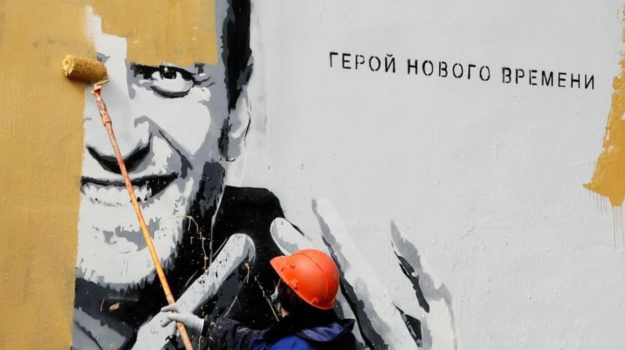Un trabajador pinta sobre un mural que representa Alexei Navalny en San Petersburgo
