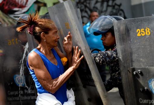 Una mujer se enfrenta a la Policía durante una protesta en Caracas en 2017