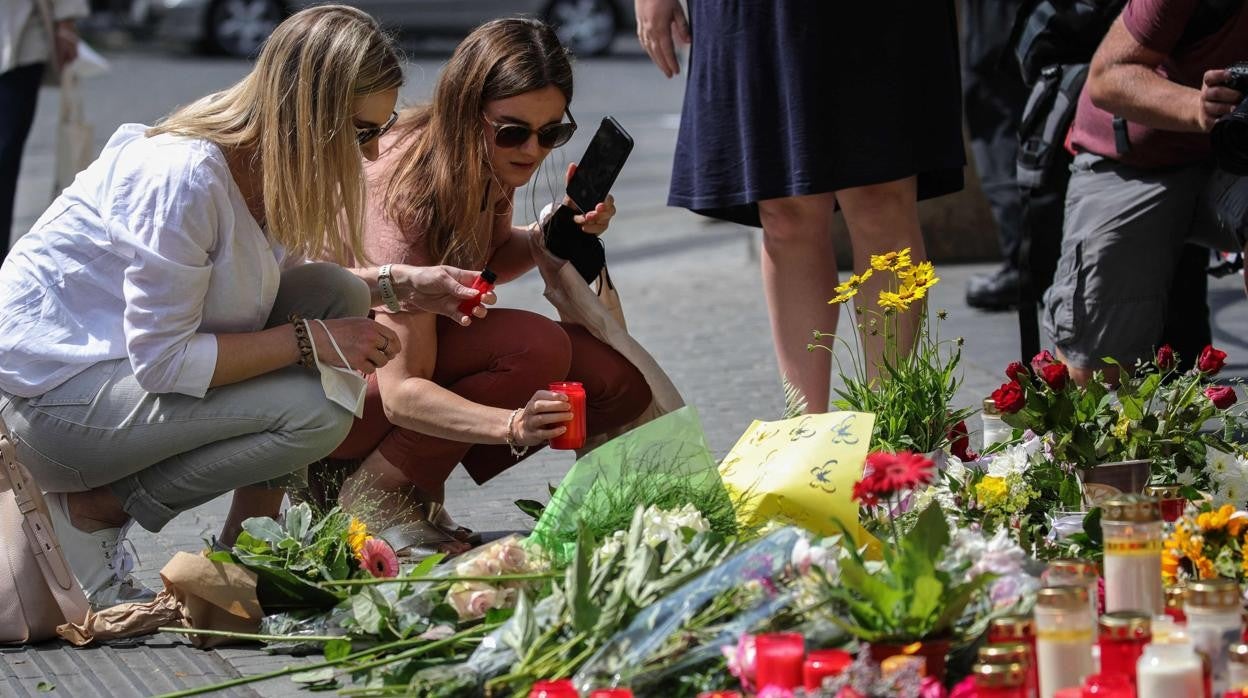 Dos mujeres colocan una vela en el memorial que la ciudad de Wurzburgo ha colocado donde se perpetró el ataque