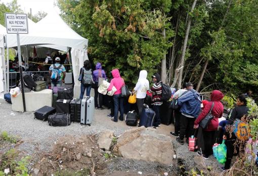 Una fila de solicitantes de asilo que se identificaron como de Haití esperan ingresar a Canadá desde Roxham Road en 2017