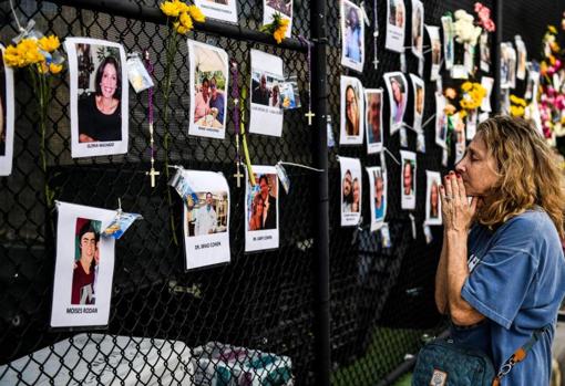 Una mujer reza ante las fotos de las víctimas y desaparecidos