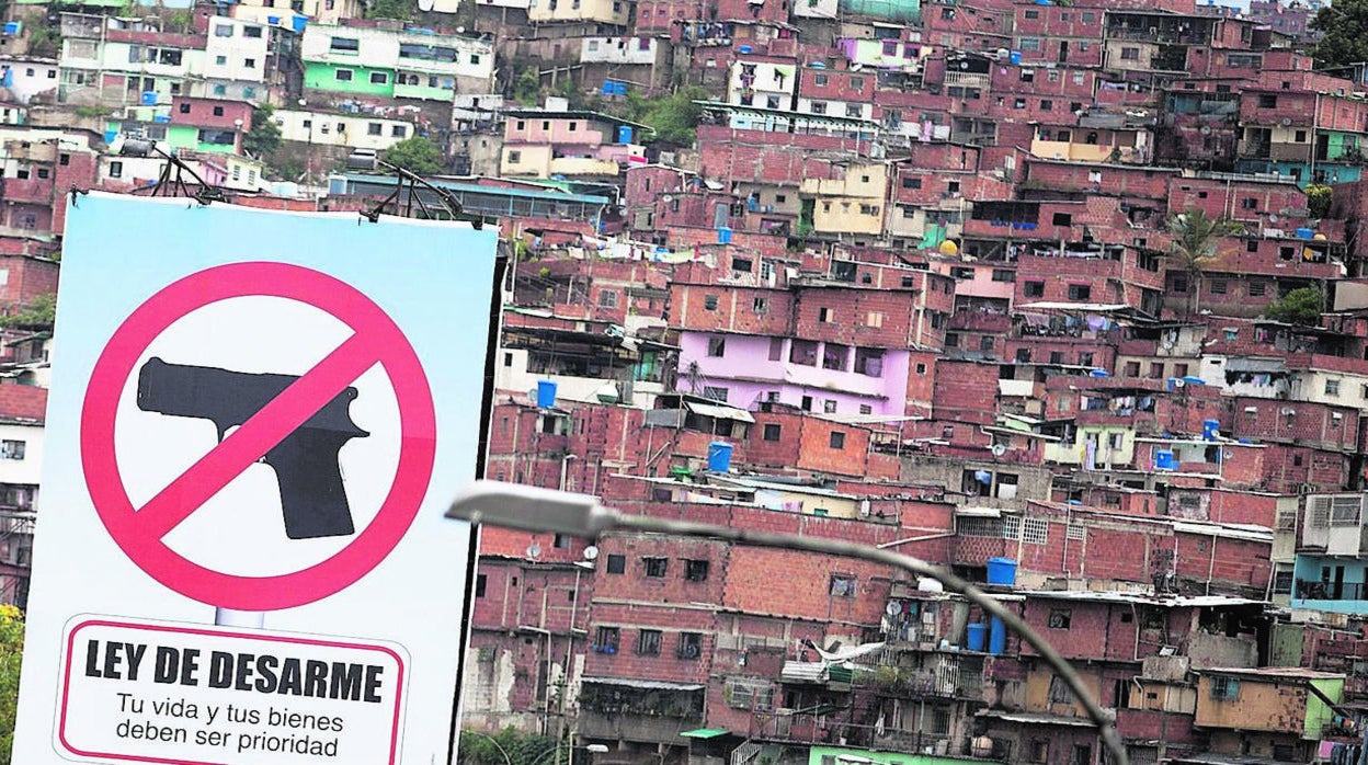 Un cartel de la ley desarme en la entrada del populoso barrio de Petare, en Caracas