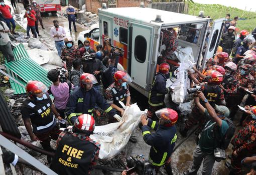 Trabajadores de emergencias recuperan cuerpos del incendio
