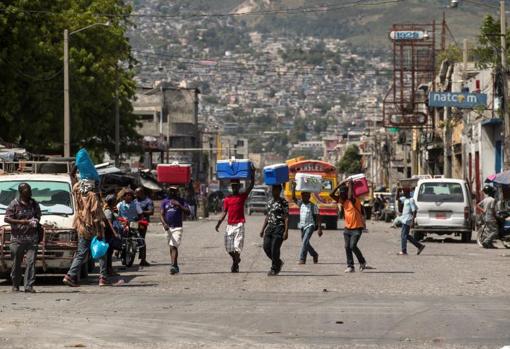 Personas caminan por una avenida comercial del centro de la ciudad hoy, en Puerto Príncipe