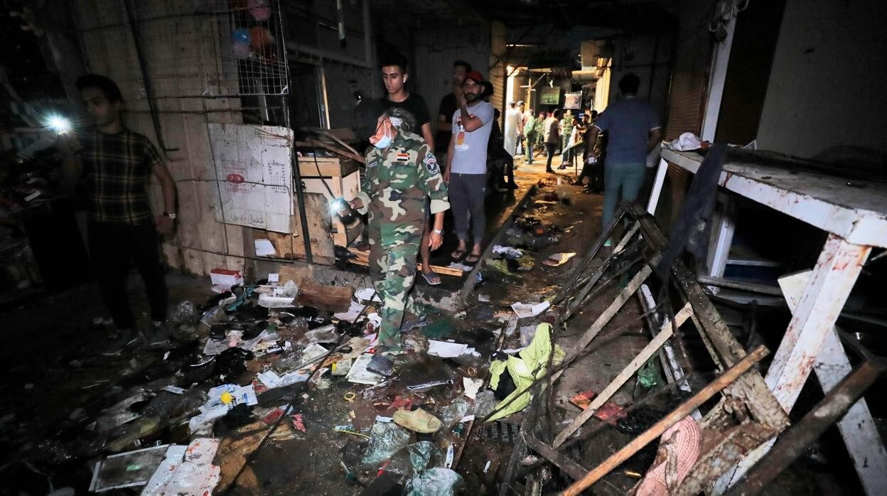 Un militar iraquí inspecciona el lugar donde fue la explosión, en Bagdad