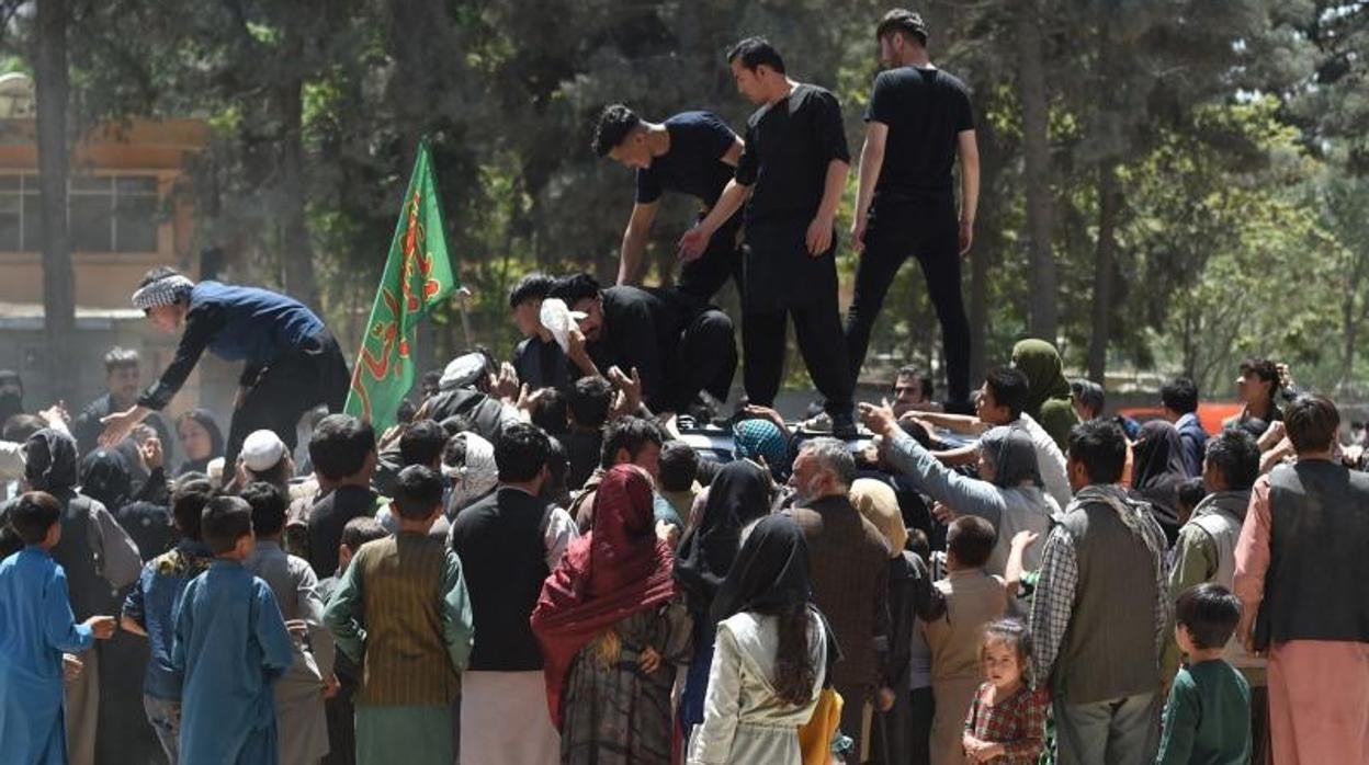 Afganos desplazados desde el norte del país para huir de los combates reciben comida en Kabul