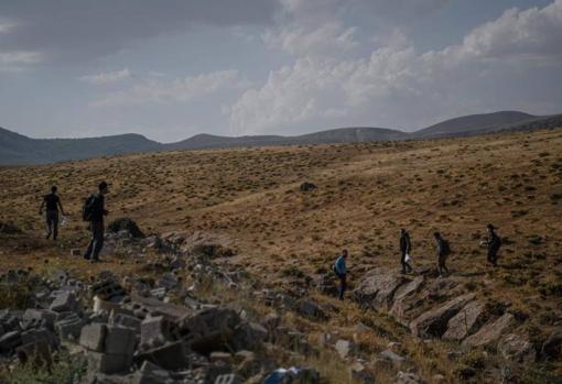 Un grupo de afganos caminan tras cruzar la frontera entre Irán y Turquía