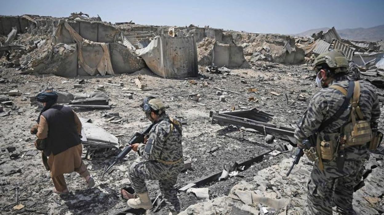 Miembros de la unidad militar talibán Badri 313 caminan entre los escombros de la base destruida de la CIA