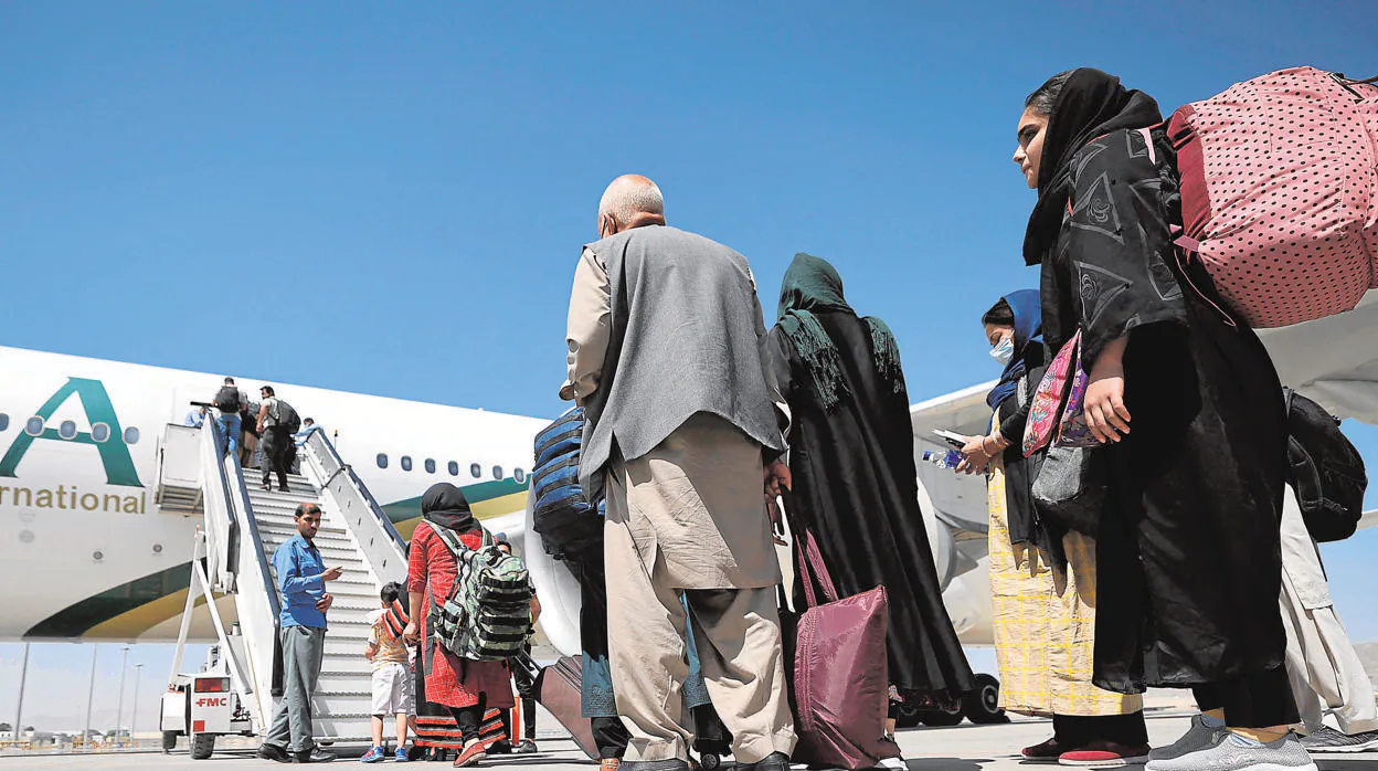 Pasajeros suben a un avión de Pakistan International Airlines, primer vuelo comercial internacional en aterrizar