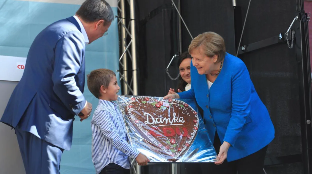 La canciller Angela Merkel recibe un tarta con la palabra 'gracias'