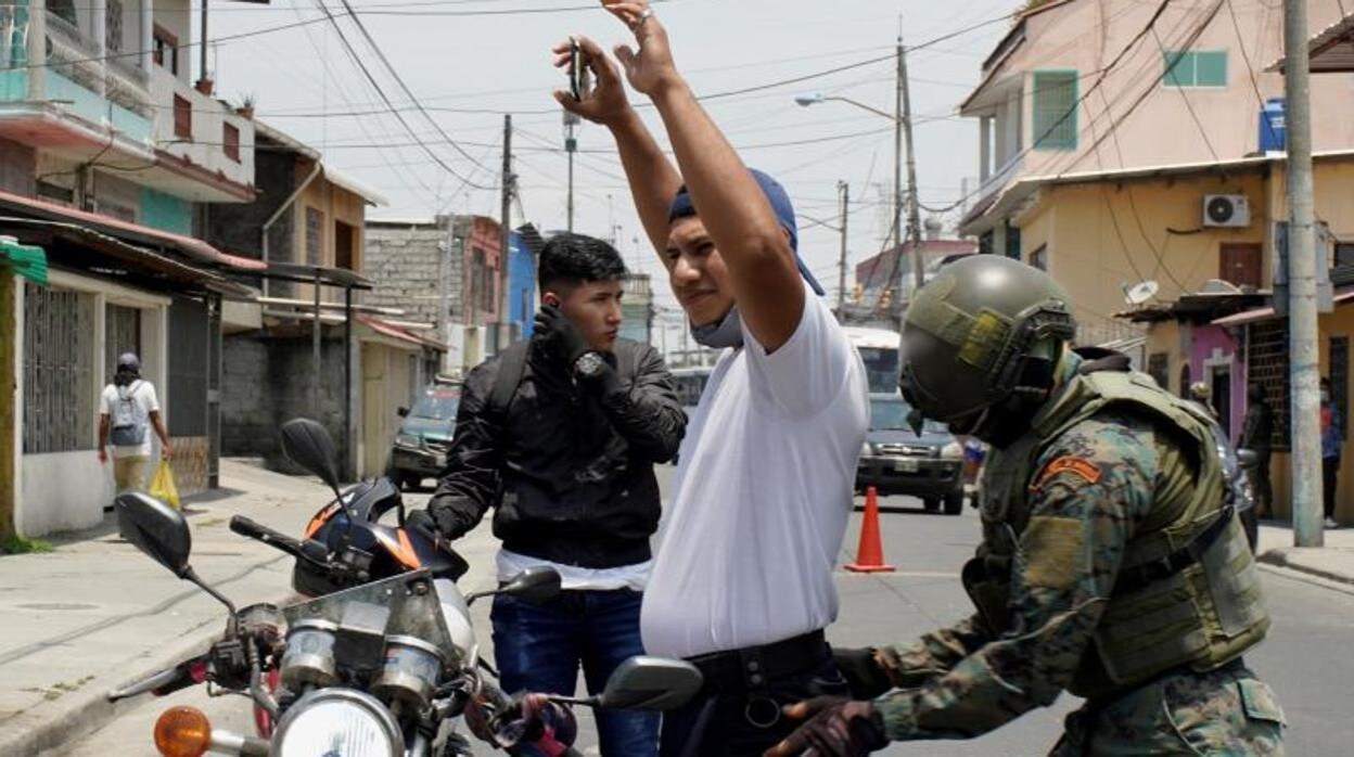 Un militar registra a un vecino en Guayaquil tras la declaración del estado de emergencia por Guillermo Lasso