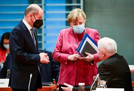 El candidato socialdemócrata a la cancillería alemana, Olaf Scholz, conversa con la actual canciller, Angela Merkel, y el ministro del Interior, Horst Seehofer