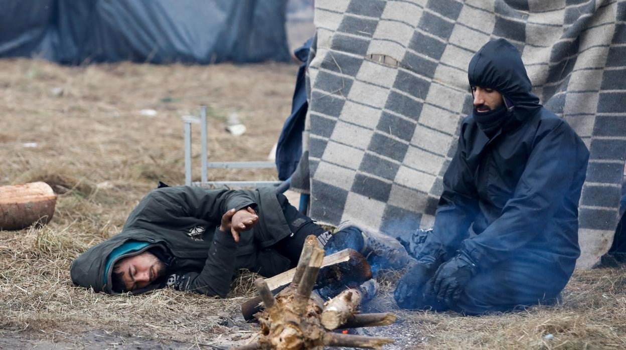 Un grupo de migrantes enciende una fogata en la región de Grodno, en Bielorrusia
