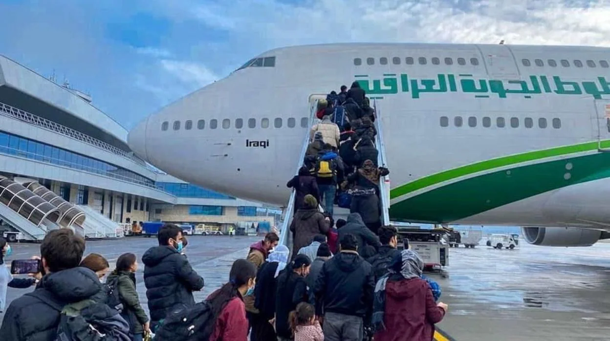 Un grupo de inmigrantes iraquíes abordan el avión para el vuelo de evacuación en el aeropuerto de Minsk, Bielorrusia