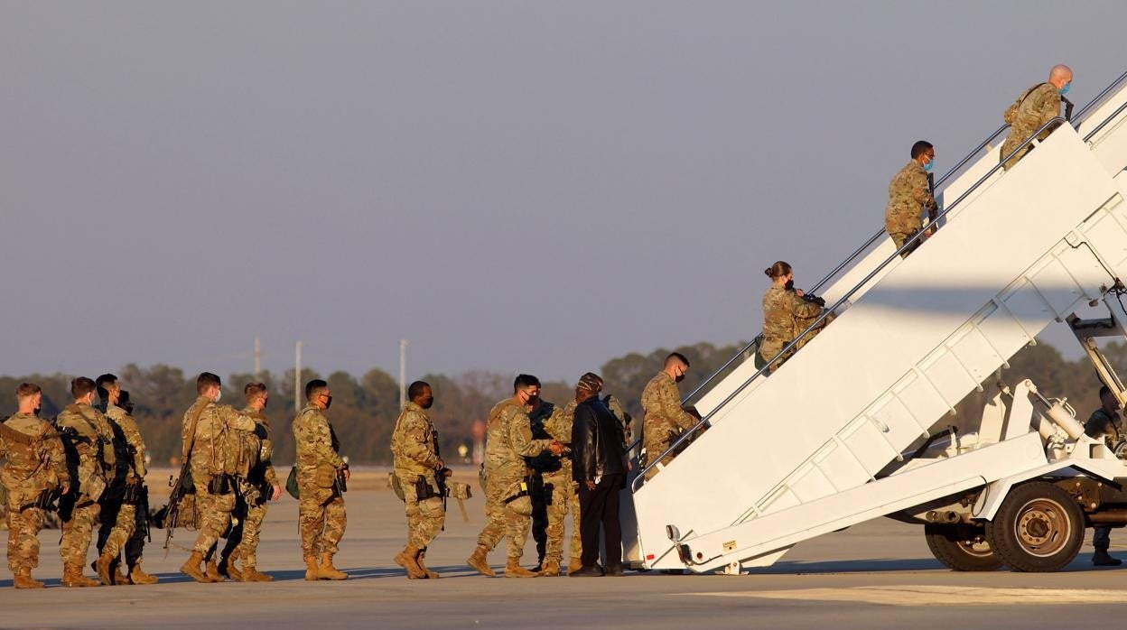 Un grupo de militares estadounidenses suben al avión en Fort Bragg rumbo a Europa