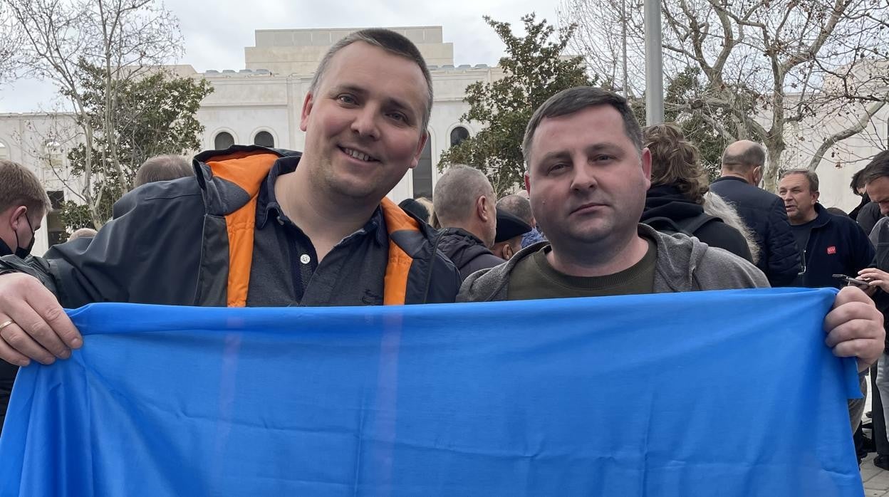 Yuriy Hladchuk y Pavlo Kovalyk posan con la bandera de Ucrania, frente a la embajada rusa en Madrid