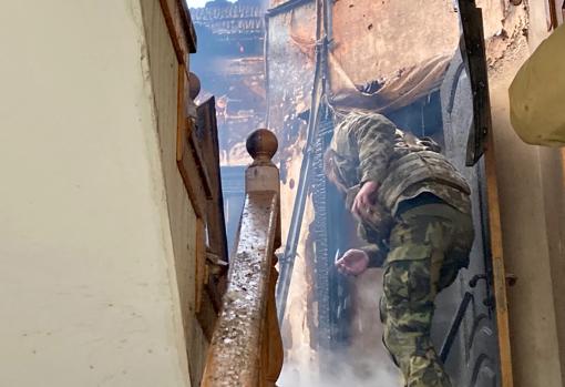 Un soldado ucraniano explora un edificio atacado en busca de heridos