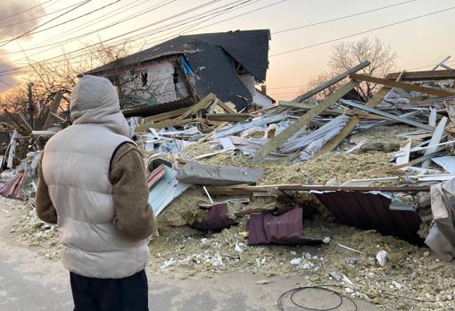 El abuelo de Katia y Nicolai observa la casa destruida de un vecino